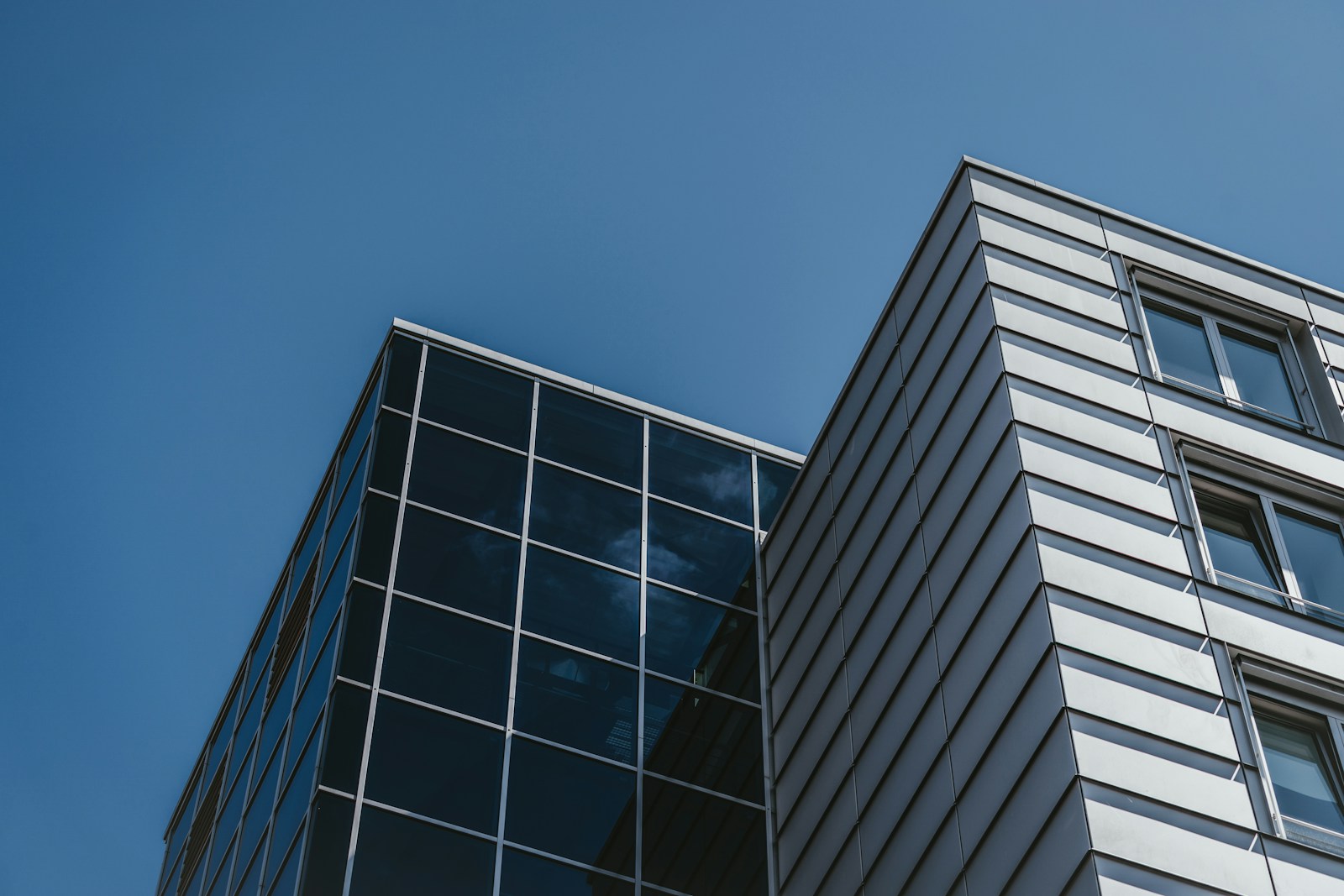 low angle photography of glass walled high rise building under blue sky during daytime, commercial property